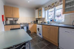 a kitchen with wooden cabinets and a washer and dryer at 1 Regent Square, Rye - for a perfect break in Rye