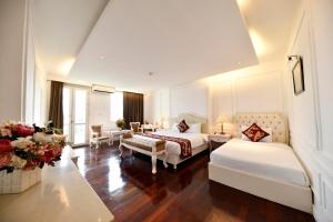 Habitación de hotel con 2 camas y sala de estar. en Hanoi Traveller House en Hanoi