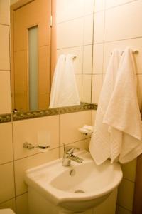 a bathroom with a sink and a mirror and towels at Onira Boutique in Tolo