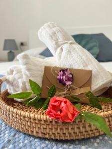 a basket with a flower on top of a bed at La Perla Marina House in Chiavari