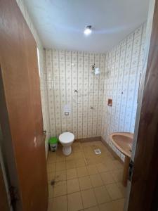 een badkamer met een toilet, een wastafel en een bad bij Açaipoint Hostel in Águas da Prata