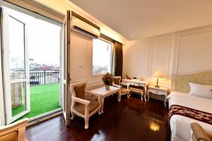 um quarto de hotel com uma cama e uma grande janela em Hanoi Traveller House em Hanói