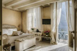 a bedroom with a bed and a tv and a window at Relais Villa Vittoria in Laglio