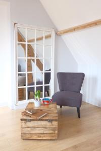 a living room with a chair and a coffee table at Thérouanne en Berry in Plaimpied-Givaudins