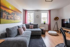 een woonkamer met een bank en een tv bij Neu! Inklusive Bettwäsche, Handtücher und vieles mehr - Perfekt für Urlaub, Familie und Workation - Boxspringbetten und Arbeitsplatz in Bad Harzburg