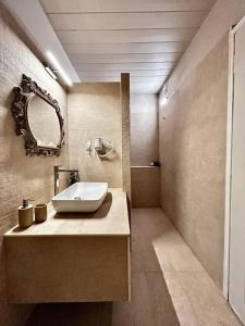Marmari Paradise Resort Hotel في مارماري: حمام مع حوض ومرآة
