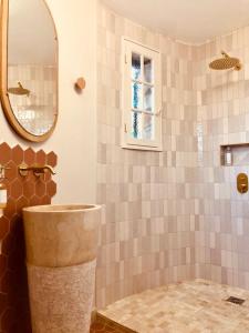 La salle de bains est pourvue d'un lavabo et d'un miroir. dans l'établissement L’Hacienda Maison d’hôtes, à Bagnols-en-Forêt