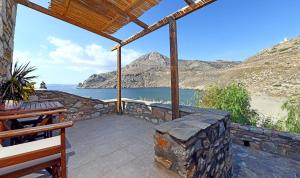 a patio with a view of the water and mountains at Marmari Paradise Resort Hotel in Marmari