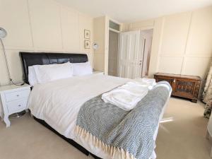 een slaapkamer met een groot wit bed en een stoel bij Rose Cottage in Bembridge