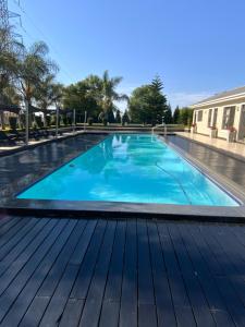 a swimming pool with blue water on a wooden deck at G Gold BNB in Fourways