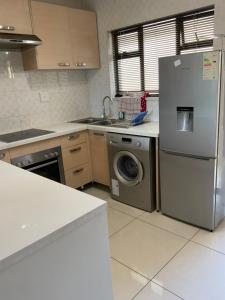 a kitchen with a refrigerator and a washing machine at G Gold BNB in Fourways