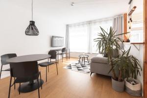 sala de estar con sofá, mesa y sillas en Koje Drei I Zentrales Apartment mit Parkplatz en Bremerhaven