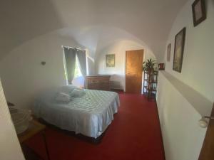 Schlafzimmer mit einem Bett, einer Kommode und einem Fenster in der Unterkunft Le gite du moulin in Lablachère