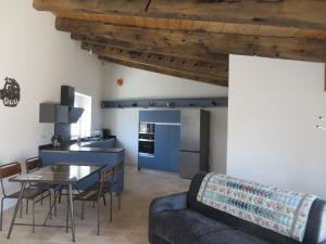 eine Küche und ein Wohnzimmer mit einem Sofa und einem Tisch in der Unterkunft Le vieux chai in Sainte-Marie-de-Ré