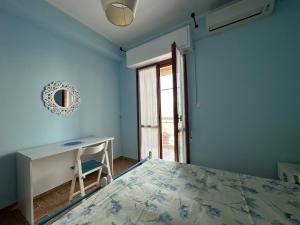 Un dormitorio con una cama y un escritorio y una ventana. en Al 205, en Alghero