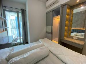 a bedroom with a large bed and a mirror at La Casa Familia at Anderson in Surabaya