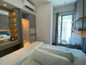 a bedroom with a large bed and a window at La Casa Familia at Anderson in Surabaya