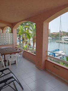 balcone con tavolo, sedie e vista sull'acqua di trilocale "Alicudi" in Portorosa a Furnari