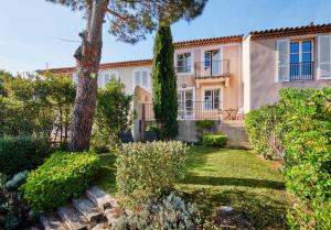 uma villa com um jardim em frente em Golf Resort & Country Club Saint-Tropez em Saint-Tropez