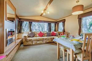 ein Wohnzimmer mit einem Sofa und einem Tisch in der Unterkunft Sandcastle Mobility Lodge in Christchurch