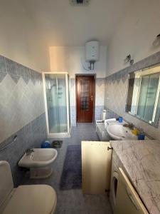 Un baño con dos lavabos, un inodoro y una bañera. en Al 205, en Alghero