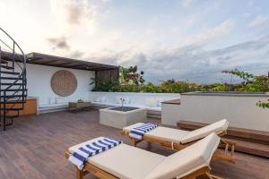 a rooftop patio with white furniture and a spiral staircase at Aquamarine Villa 1 Canggu in Canggu