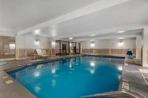a large swimming pool with blue water in a building at Comfort Suites Atlanta Airport in Forest Park