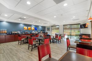 a restaurant with tables and chairs and a bar at Comfort Suites Atlanta Airport in Forest Park