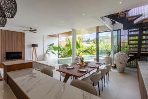 a dining room and living room with a table and chairs at Aquamarine Villa 1 Canggu in Canggu