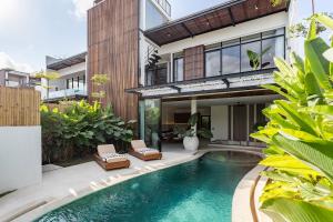 a house with a swimming pool in front of a house at Aquamarine Villa 1 Canggu in Canggu