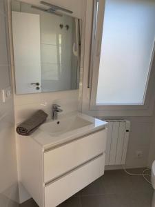 a white bathroom with a sink and a mirror at Chalet en Aldán in Cangas de Morrazo
