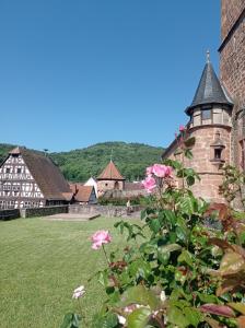 a building with a tower and flowers in a yard at Gästehaus Hoffmann in Dörrenbach