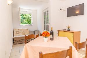 a dining room with a table with a bottle of wine at Apartment Knezevic in Petrovac na Moru