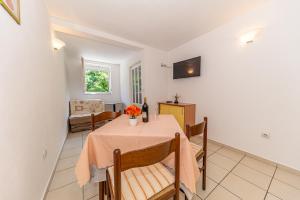 une salle à manger avec une table, des chaises et une télévision dans l'établissement Apartment Knezevic, à Petrovac na Moru