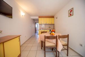 - une cuisine et une salle à manger avec une table et des chaises dans l'établissement Apartment Knezevic, à Petrovac na Moru