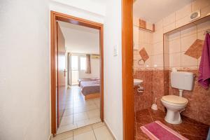 a bathroom with a toilet and a bedroom at Apartment Knezevic in Petrovac na Moru