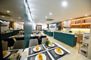 ein Restaurant mit Tischen und Teller mit Speisen darauf in der Unterkunft Hanoi Traveller House in Hanoi