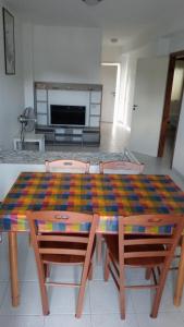 einen Tisch mit einem bunten Tischtuch darauf im Wohnzimmer in der Unterkunft trilocale "Lipari" in Portorosa in Torre Forte