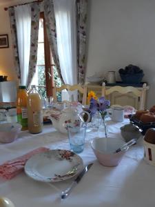 a table with plates and bowls on a white table cloth at Thérouanne en Berry in Plaimpied-Givaudins