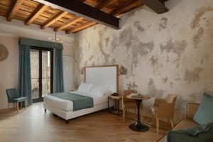 um quarto com uma cama e um sofá em Cà Uberti Palace Hotel em Mântua