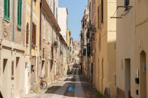 Un callejón entre dos edificios con una bicicleta encima. en CityCenter blue, en Alghero