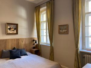 a bedroom with a bed and two windows at ciao-aschau Haus zur Burg Ap112 Burgblick in Aschau