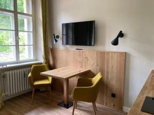 una sala da pranzo con tavolo, sedie e TV a parete di ciao-aschau Haus zur Burg Ap112 Burgblick a Aschau