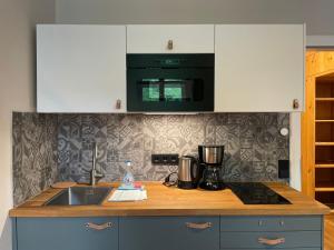 a kitchen counter with a sink and a microwave at ciao-aschau Haus zur Burg Ap112 Burgblick in Aschau