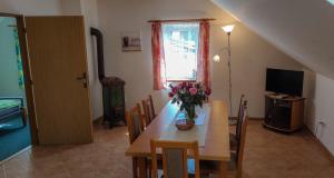 a dining room with a table with a vase of flowers at Apartmán na Koskách in Třeboň
