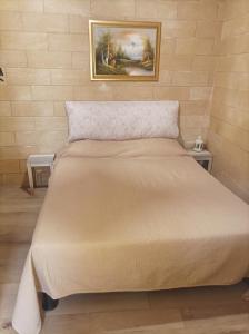 a bed in a bedroom with a picture on the wall at Il sottano borgo antico in Bari