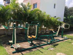 an empty playground in a yard with palm trees at Apto. Luxury con Piscina “Brisa del paraíso¨ in Concepción de La Vega