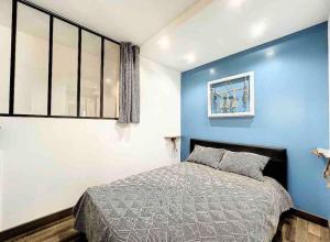 1 dormitorio con 1 cama con pared azul en Casa Victor - Jardin privatif, proche plage et centre en Calvi