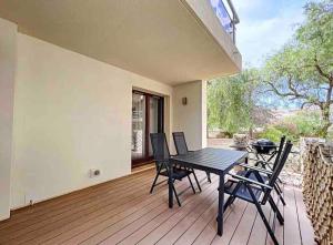 patio con tavolo e sedie su una terrazza di Casa Victor - Jardin privatif, proche plage et centre a Calvi