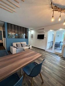 sala de estar con mesa de madera y sillas en Casa Victor - Jardin privatif, proche plage et centre en Calvi